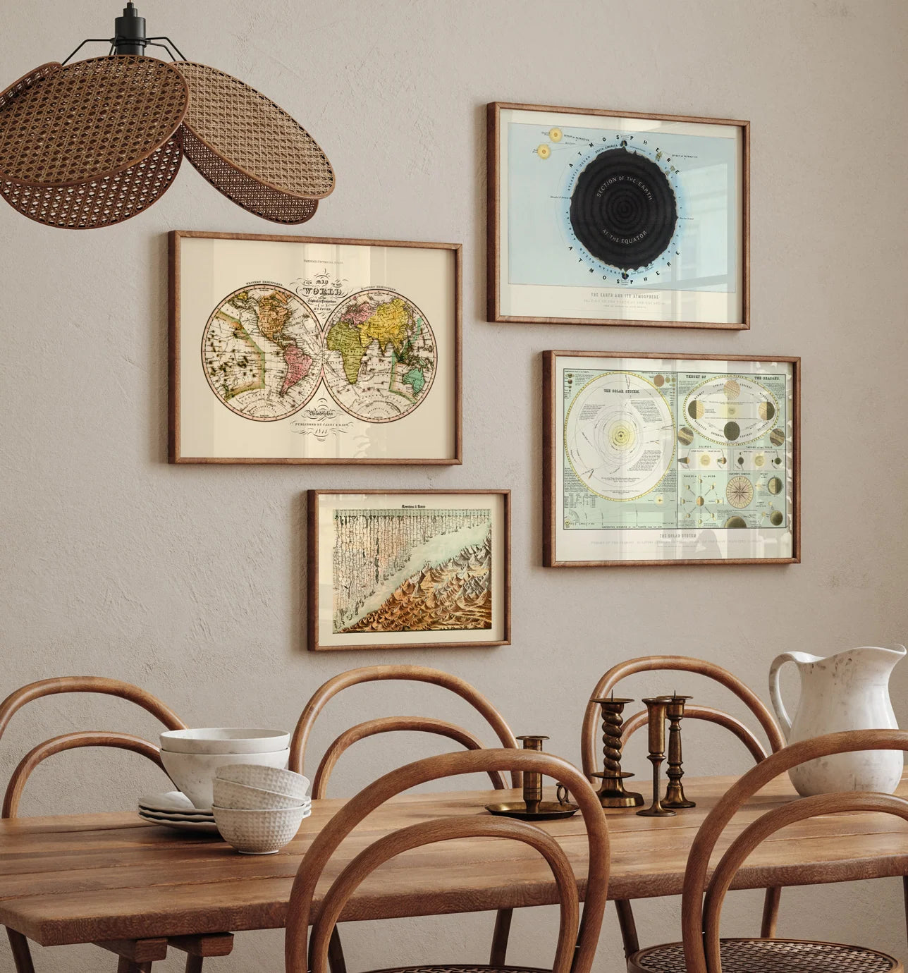 A styled dining room scene with a wooden table, woven chairs, a hanging pendant light, and four framed vintage-style wall prints arranged on a beige wall.