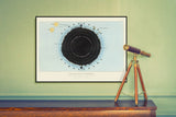 A framed art print featuring a circular black-and-white diagram on a pale blue background, hung on a light green wall above a wooden console table. A brass telescope sits on the table to the right.