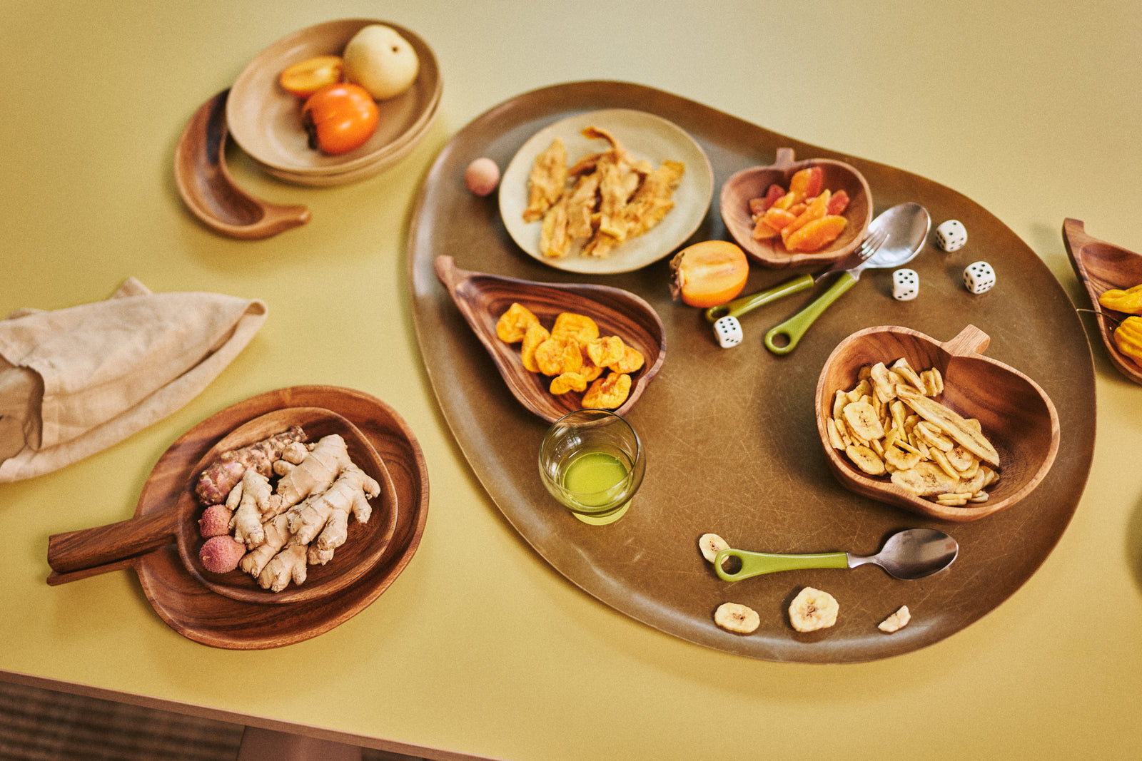 Diverse food items on a wooden tray with a yellow background