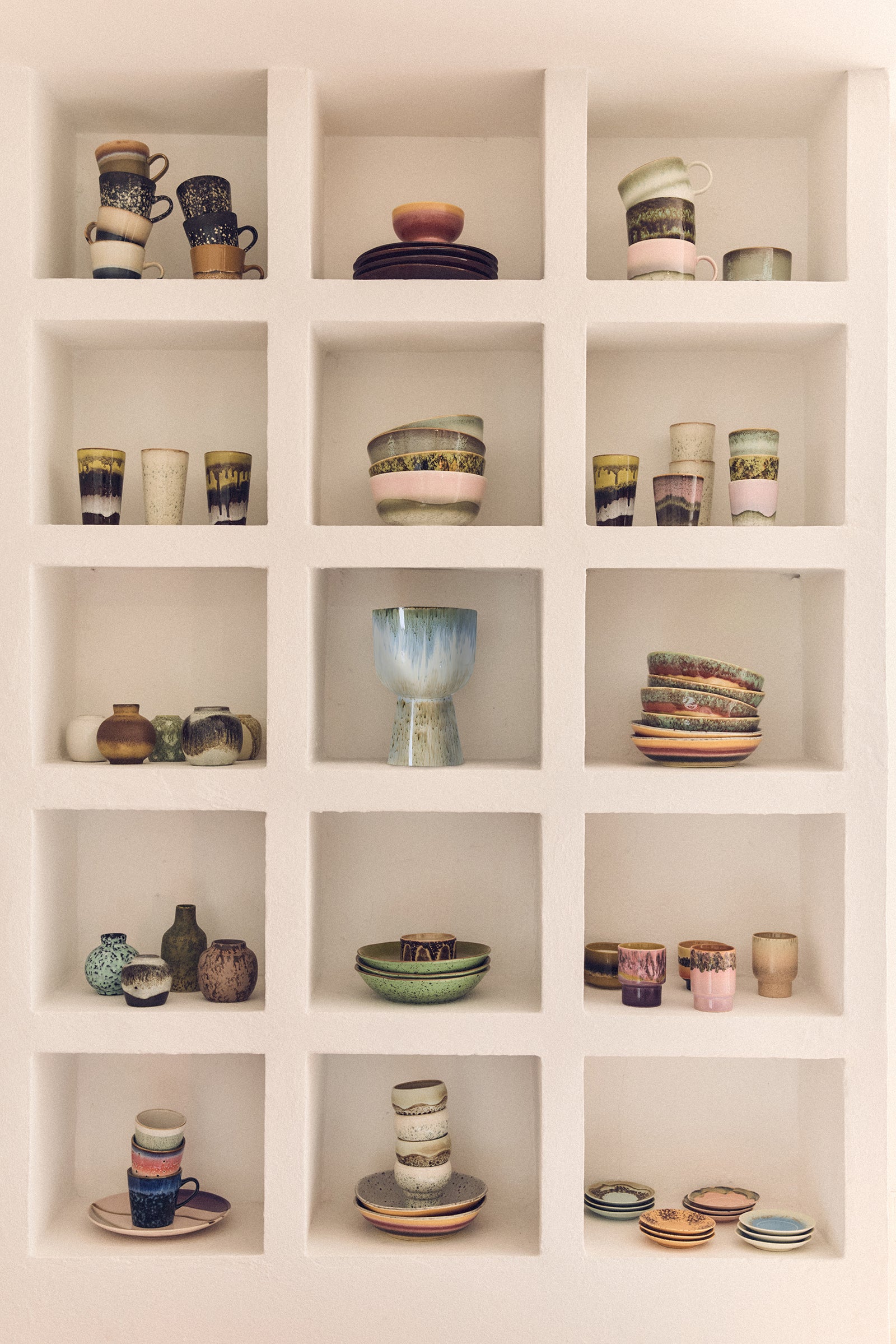 Shelves filled with various ceramic items including cups, bowls, and vases.