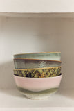 Stack of ceramic bowls with different patterns on a neutral background