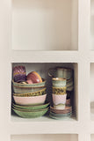 Set of ceramic bowls and cups in a white cabinet