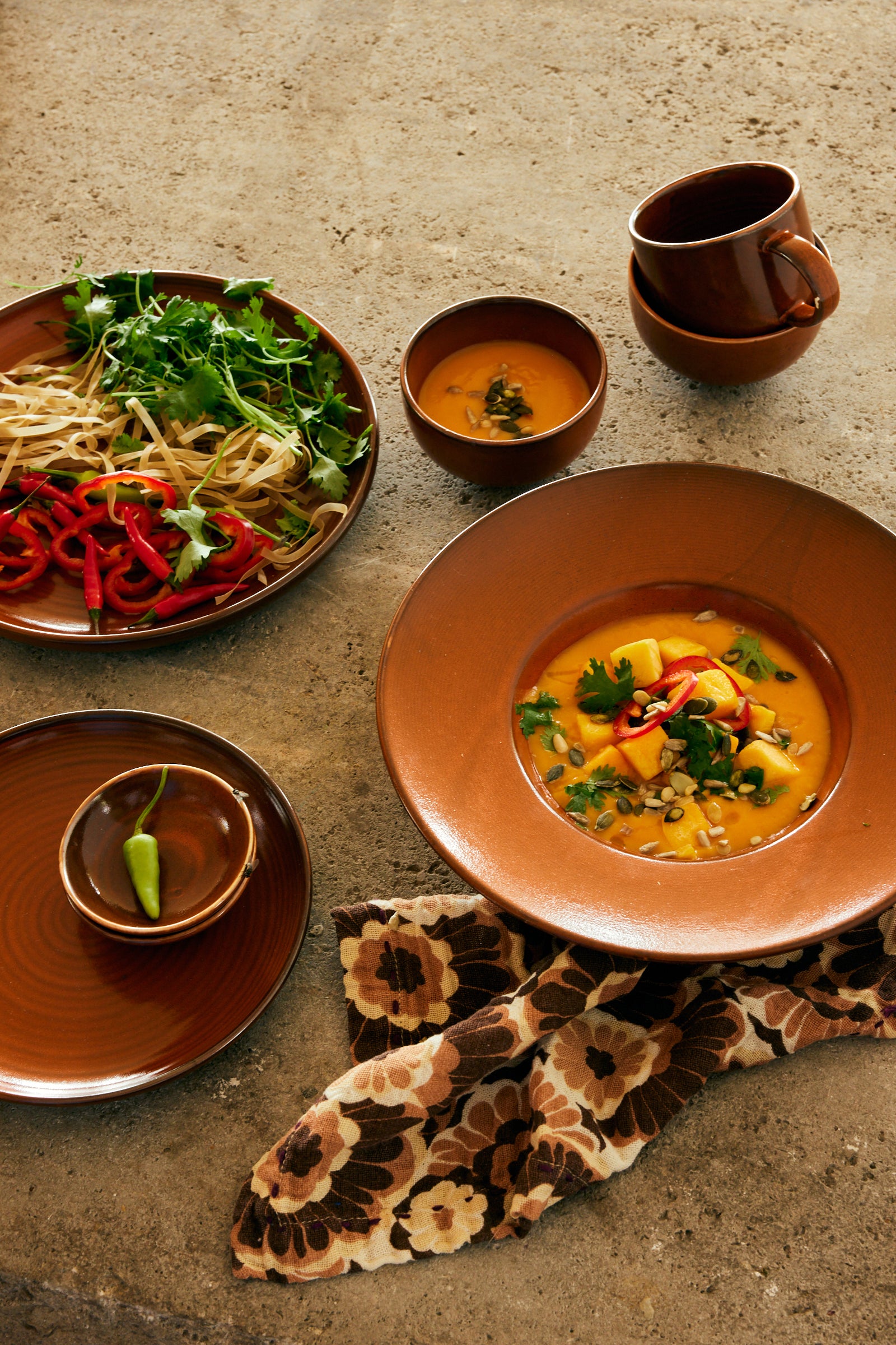 Dishes of food on a textured surface with a patterned napkin.