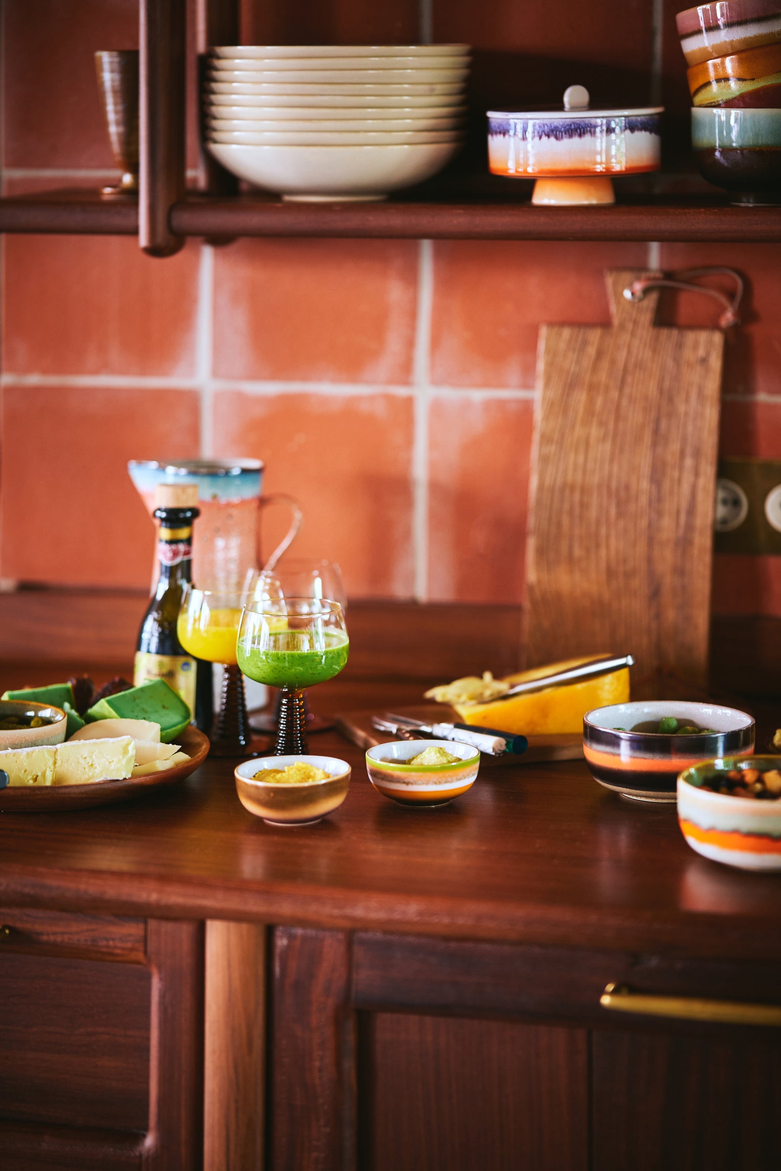 Kitchen counter with various items including bowls, bottles, and a cutting board.