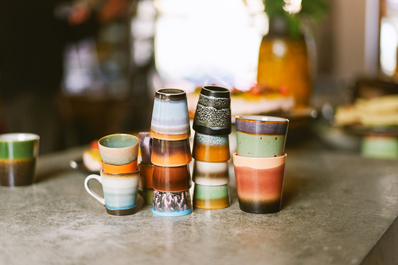 Set of colorful ceramic cups on a stone surface