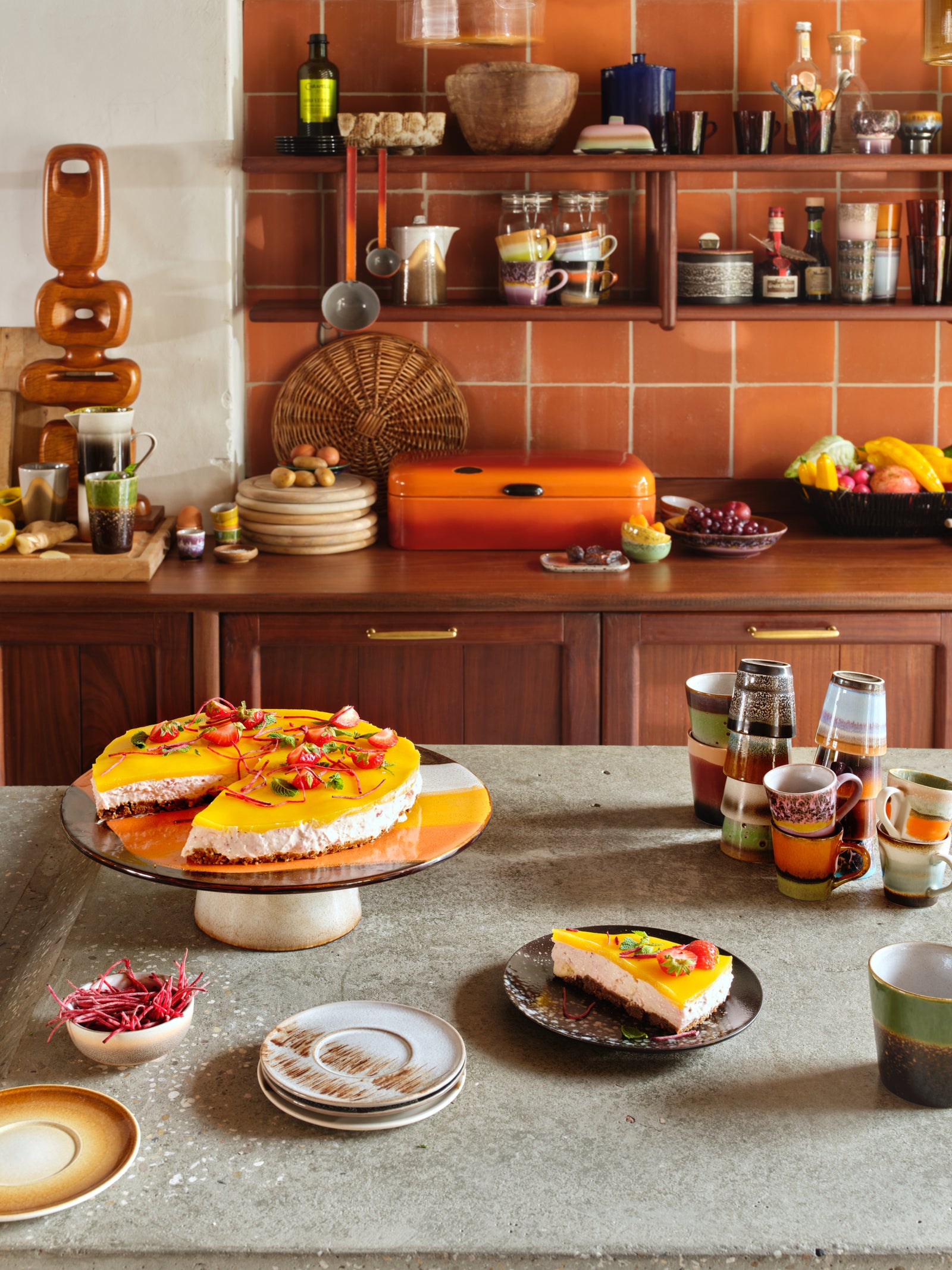 Dessert table with a cake and various dishes in a kitchen setting