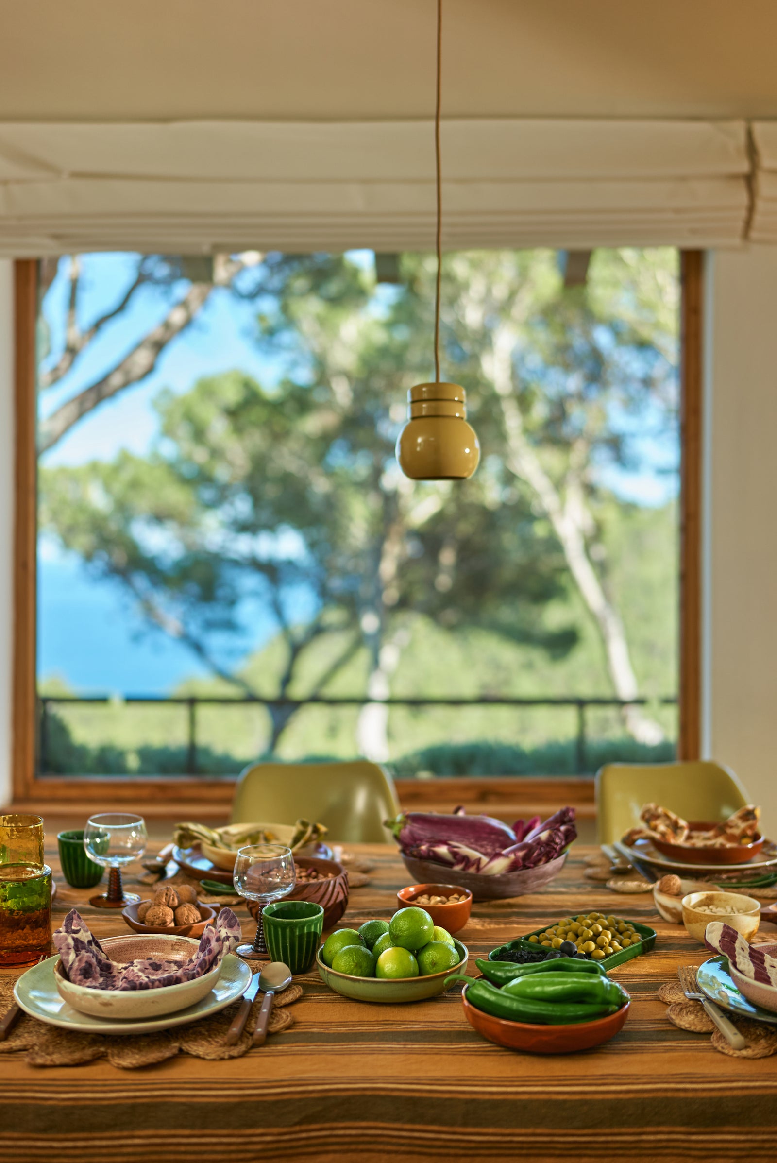 Dining table set with various dishes and a view of trees outside