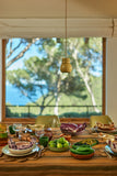 Dining table set with various dishes and a view of trees outside