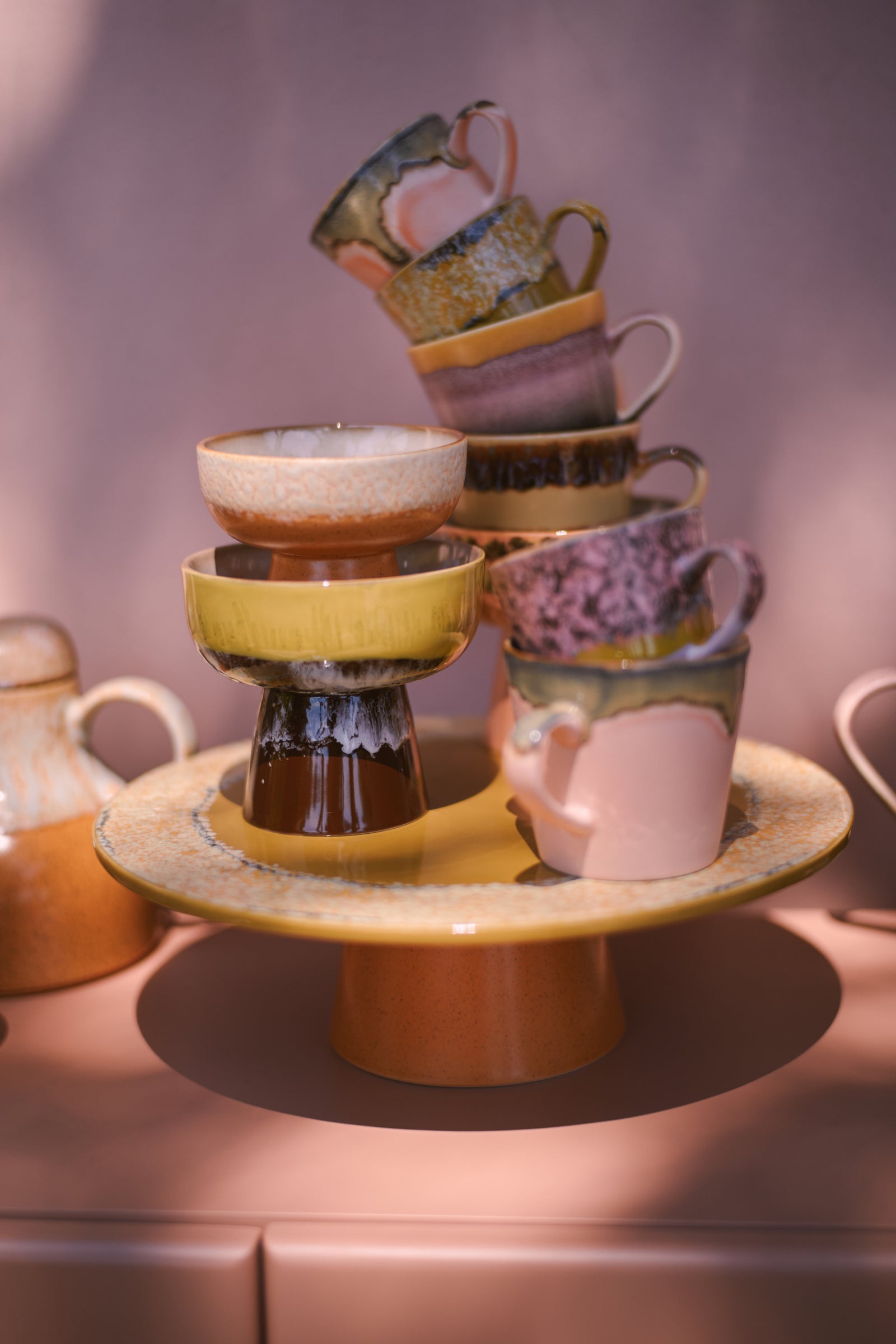Stack of ceramic cups and bowls on a stand with a blurred background