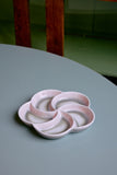 Pink ceramic dish on a gray surface with blurred background