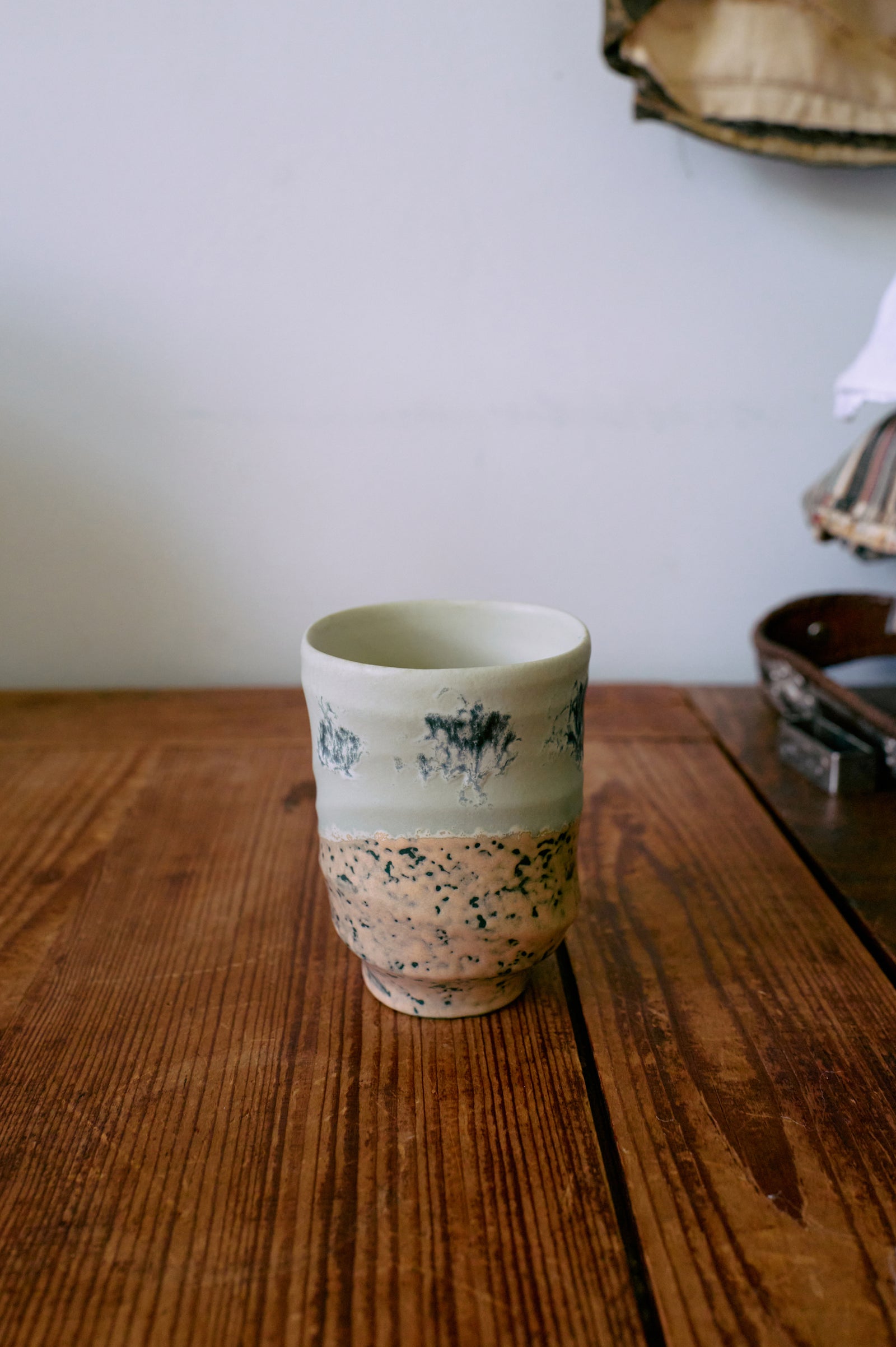 Ceramic cup with speckled design on a wooden surface