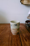 Ceramic cup with speckled design on a wooden surface