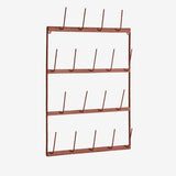 A copper-colored metal wall rack with four horizontal bars and multiple vertical hooks, shown against a plain light gray background.