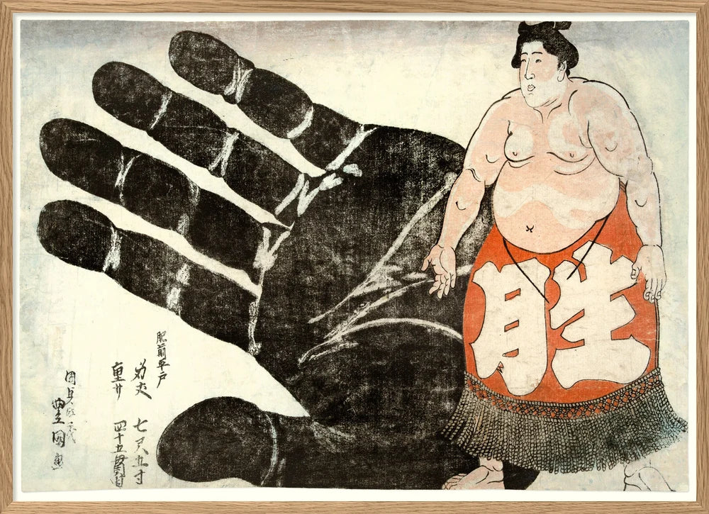 A framed Japanese-style art print depicting a large black hand with white calloused fingertips beside a sumo wrestler wearing an orange-red mawashi with large white characters, on an off-white background.