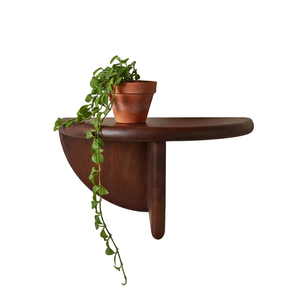 Wooden shelf with a glass vase on a beige wall