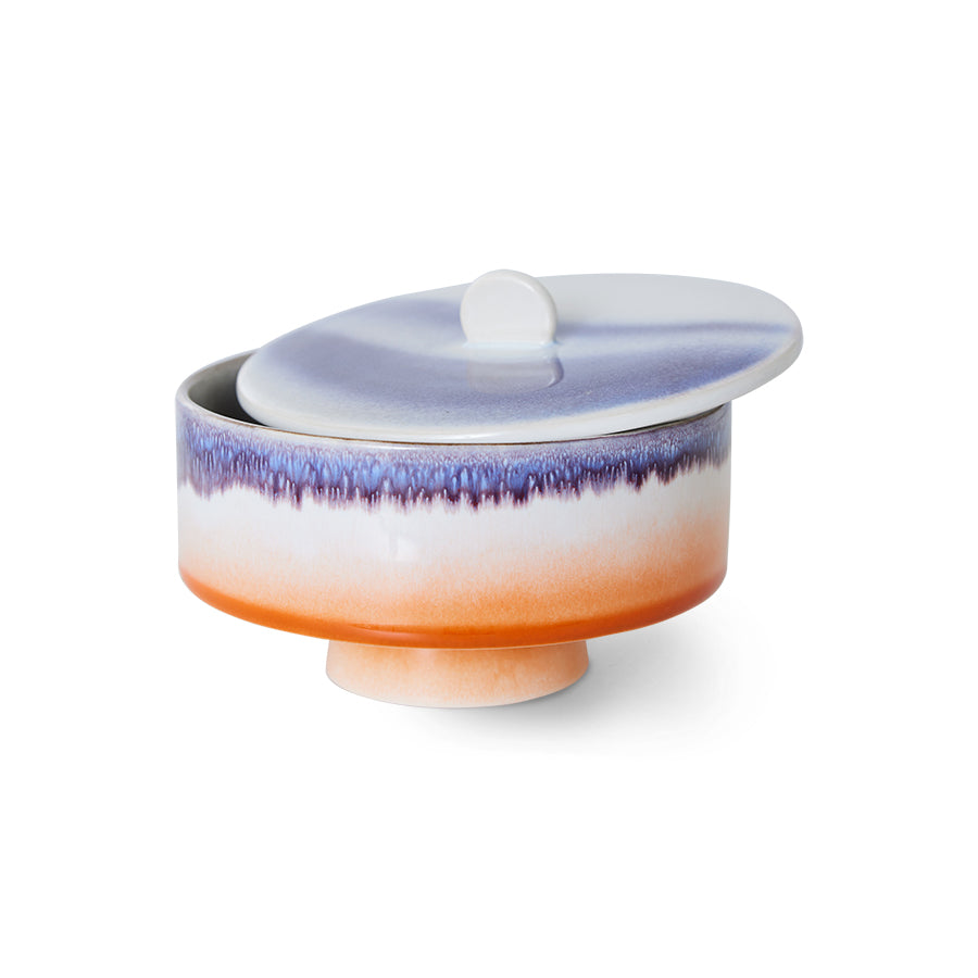 Decorative ceramic container with a gradient design on a white background