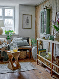 Cozy living room with wooden furniture, plants, and decorative items.
