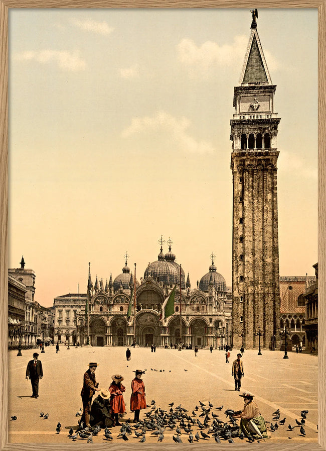 Vintage-style print of Venice's San Marco Square, featuring the Campanile tower, St. Mark's Basilica, and people feeding pigeons in the foreground, shown within a light wood frame.