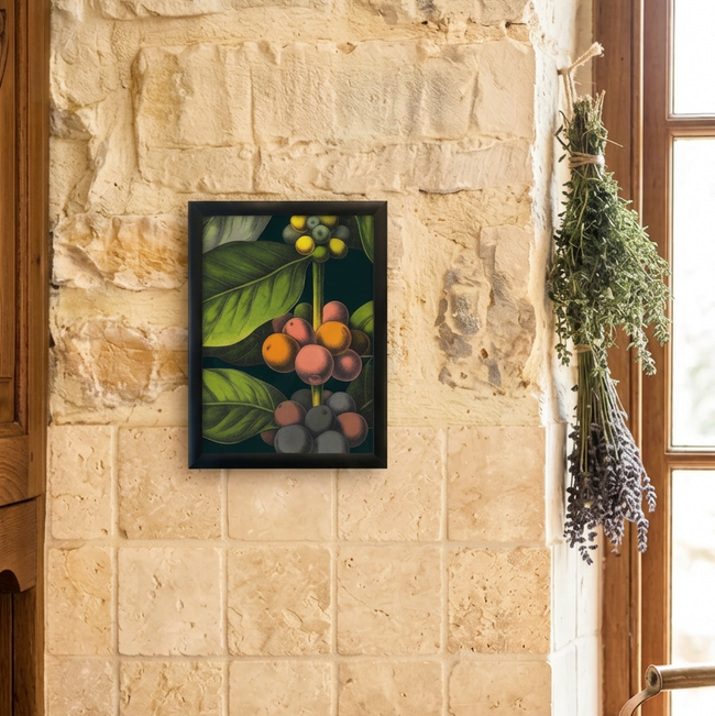 A framed botanical art print depicting green leaves and colorful cherries hangs on a rustic stone wall above a wooden counter with coffee beans, a mortar and pestle, and a French press in a warm kitchen setting.