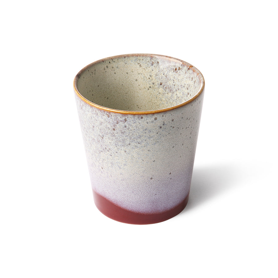 Speckled ceramic cup with a gradient color on a white background