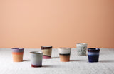Set of ceramic cups with gradient colors on a neutral background