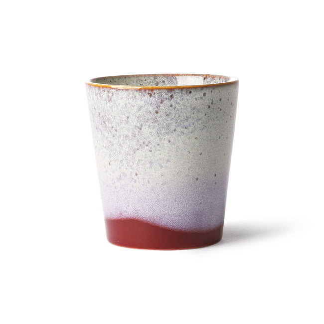 Speckled ceramic cup with gradient color on a white background