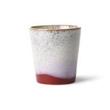 Speckled ceramic cup with gradient color on a white background