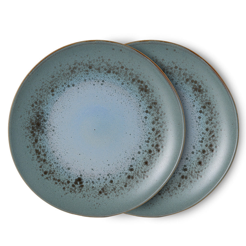 Two blue ceramic plates with speckled design on a white background
