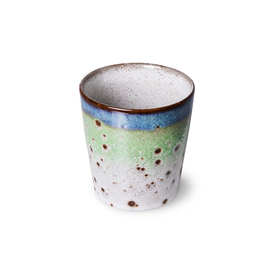 Ceramic cup with speckled design on a white background