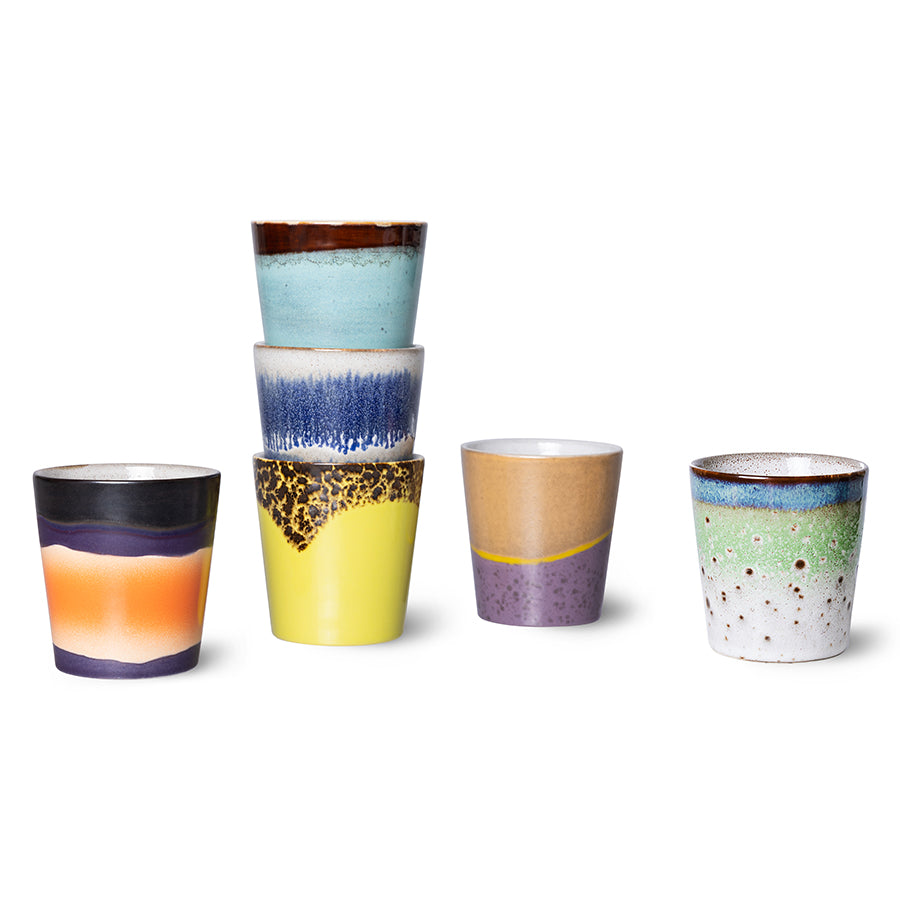 Set of colorful ceramic cups with gradient patterns on a white background