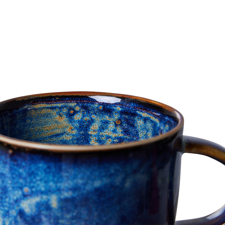 Blue ceramic mug with a speckled design on a white background