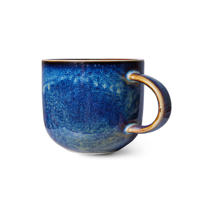 Blue ceramic mug with a speckled texture on a white background