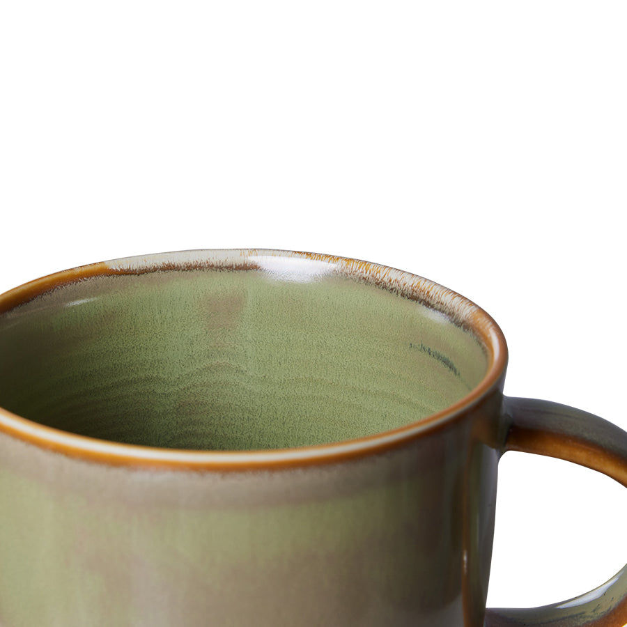 Green ceramic mug with brown rim and handle on a white background