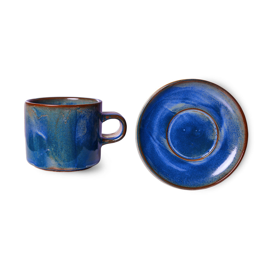 Blue ceramic mug and saucer set on a white background