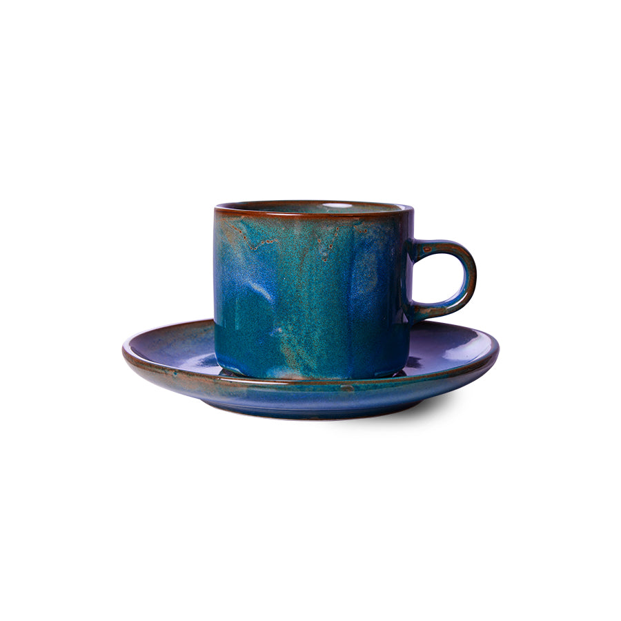 Blue ceramic cup and saucer set on a white background