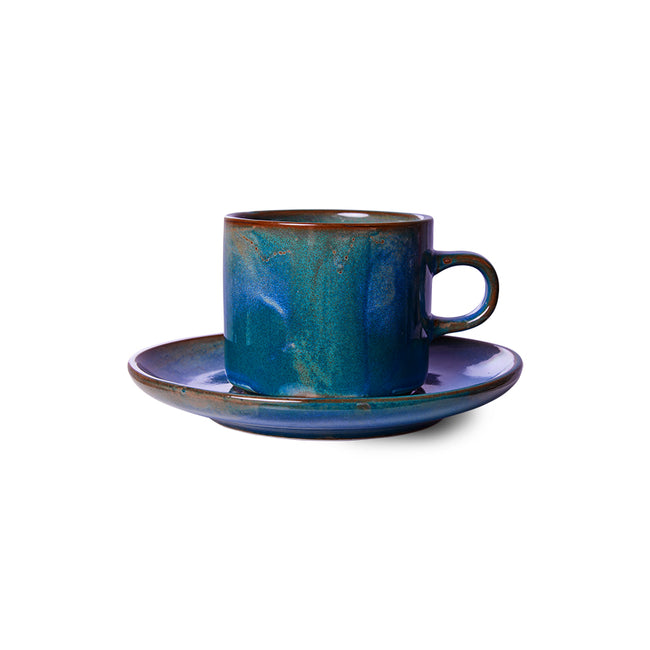 Blue ceramic cup and saucer set on a white background
