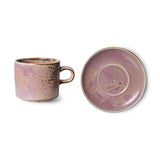 Ceramic mug and saucer set with a purple glaze on a white background