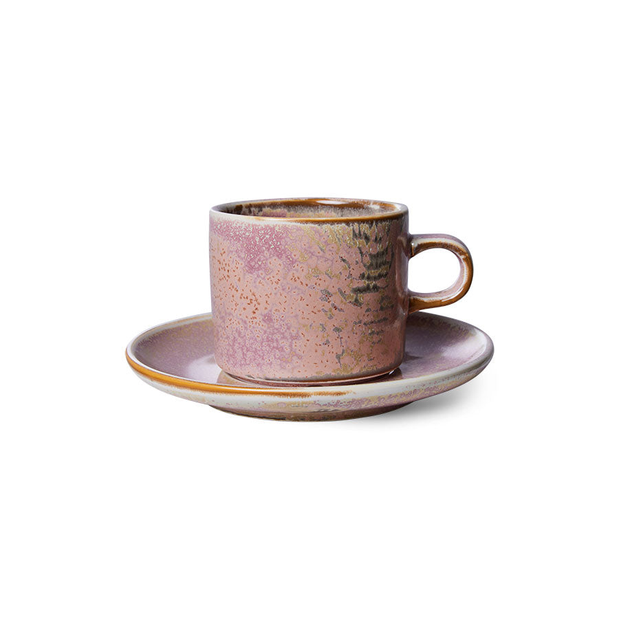 Ceramic cup and saucer with a speckled design on a white background