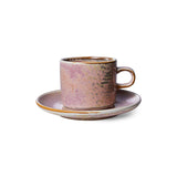 Ceramic cup and saucer with a speckled design on a white background