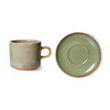 Green ceramic mug and saucer set on a white background