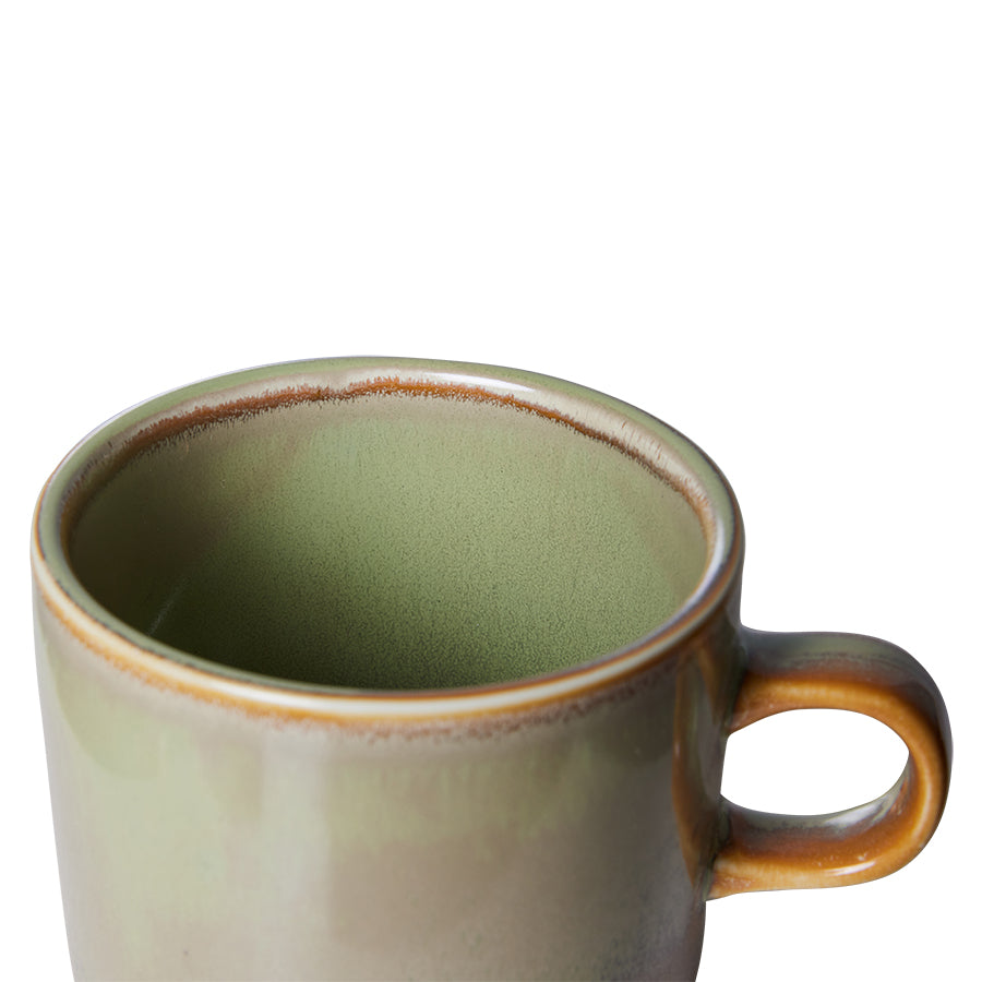 Green ceramic mug with brown rim and handle on a white background