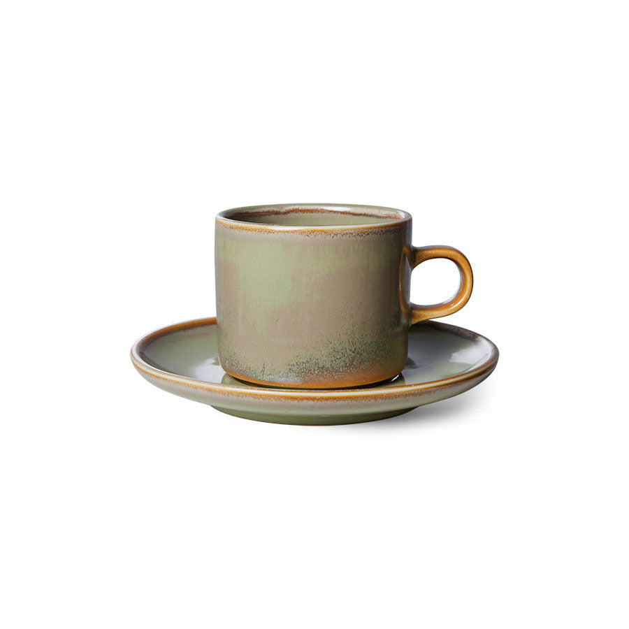 Green ceramic cup and saucer on a white background