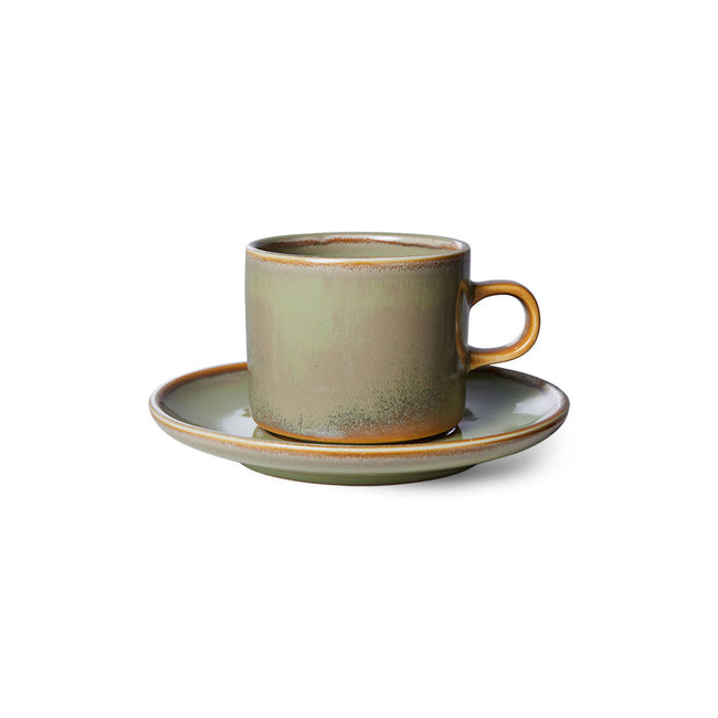 Green ceramic cup and saucer on a white background