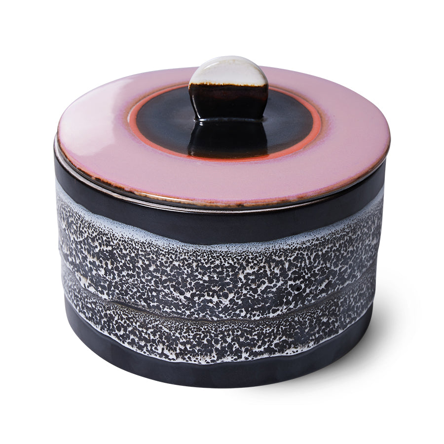 Ceramic container with pink lid and speckled design on a white background