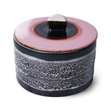 Ceramic container with pink lid and speckled design on a white background