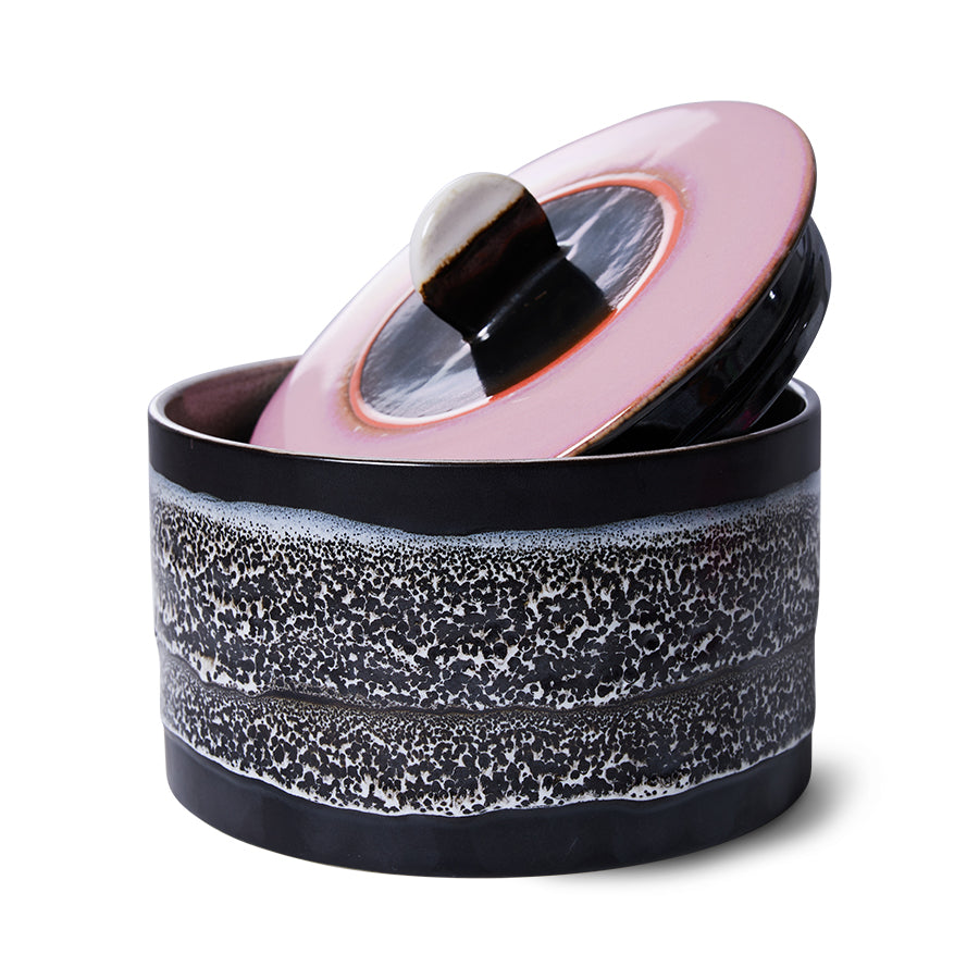 Ceramic container with speckled design and pink lid on a white background