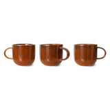 Three brown ceramic mugs on a white background