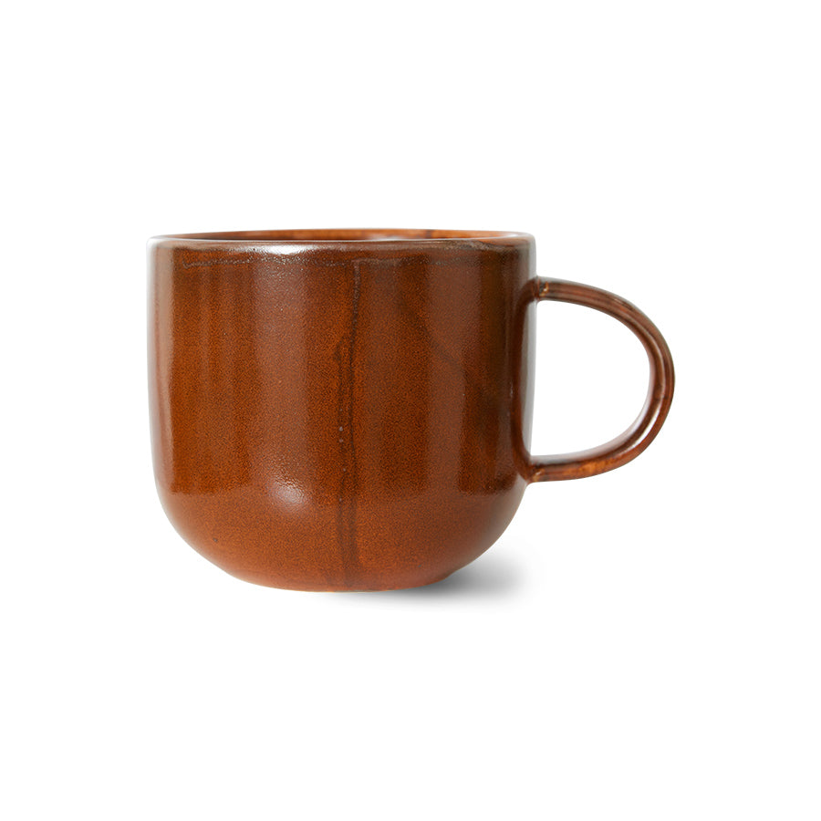 Brown ceramic mug with a handle on a white background