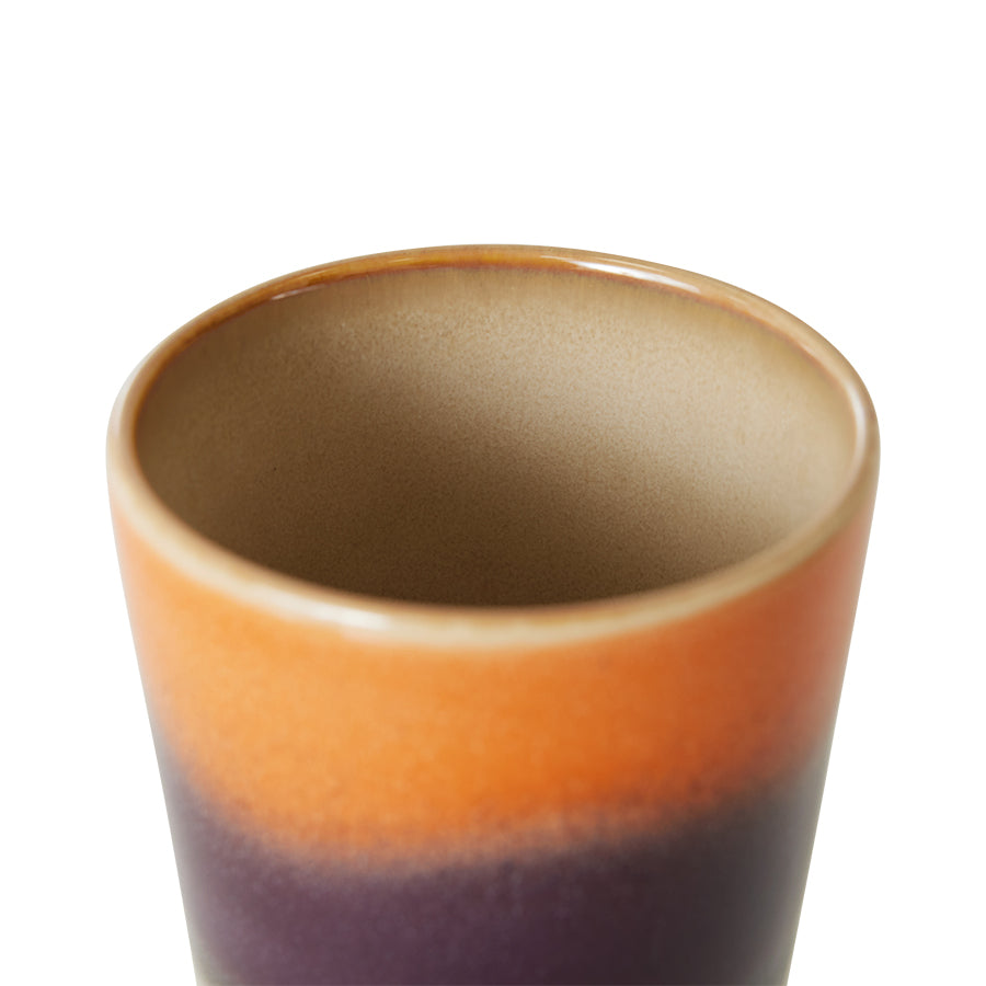 Ceramic cup with gradient color from brown to purple on a white background