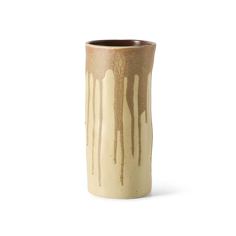 A handmade ceramic cylinder vase with a dripping glaze design, featuring a warm brown top section and a cream-colored lower body with brown drips, set against a plain white background.